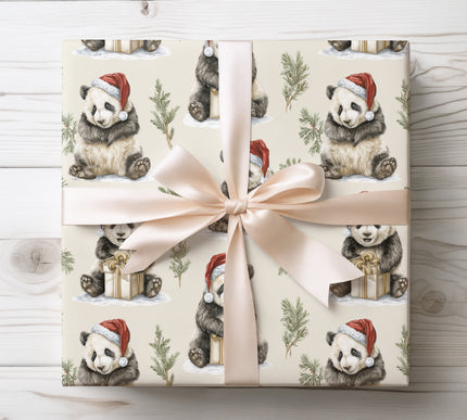 Charming wrapping paper with panda cubs in Santa hats surrounded by holiday greenery, ideal for seasonal gifts.