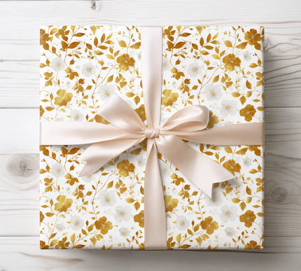 Gold foil flowers and branches on white wrapping paper 